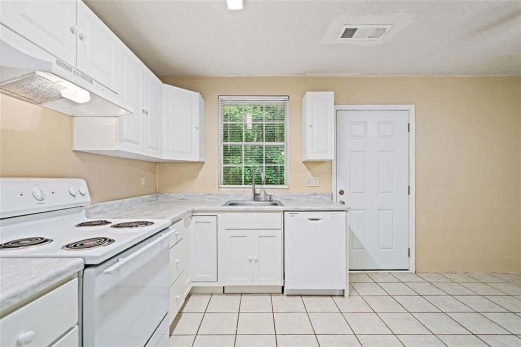 1628 Rockmart Road Villa Rica, GA 30180 - Photo 18 of 40 a kitchen with granite countertop white cabinets and white appliances
