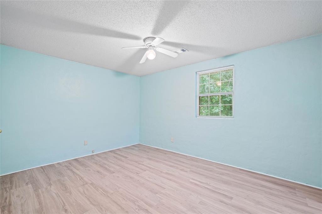 1628 Rockmart Road Villa Rica, GA 30180 - Photo 24 of 40 an empty room with wooden floor fan and windows