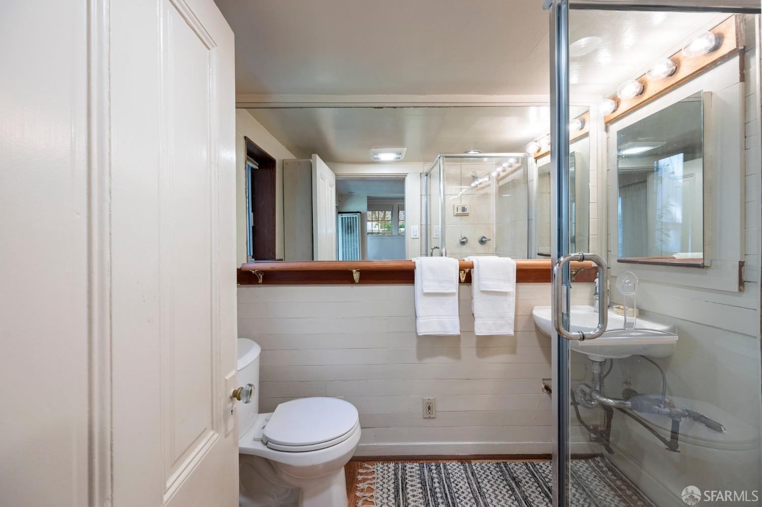 1659 Jackson Street San Francisco, CA 94109 - Photo 5 of 27 a bathroom with a sink a toilet and a mirror