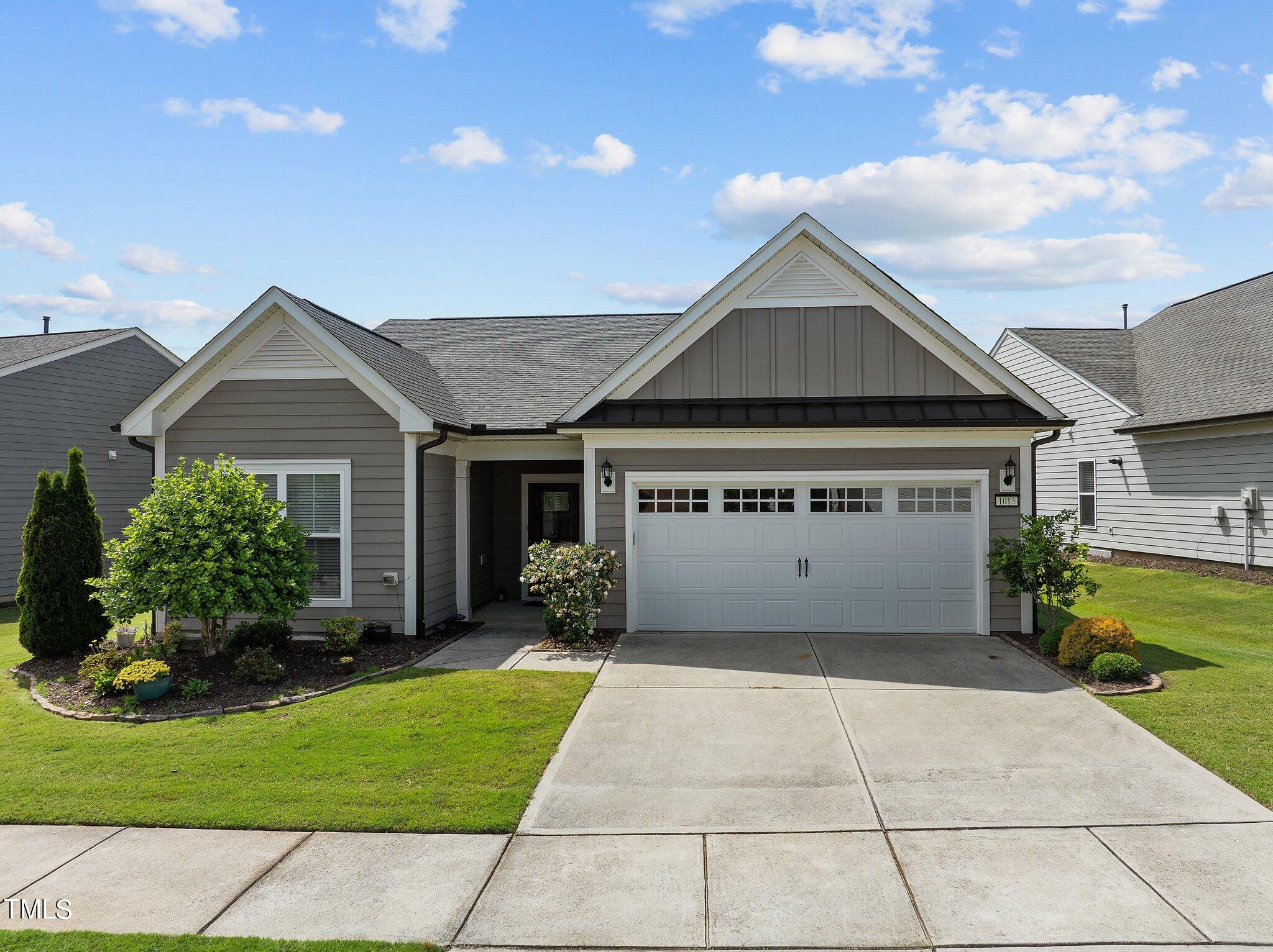 a view of a house with a yard and potted plants