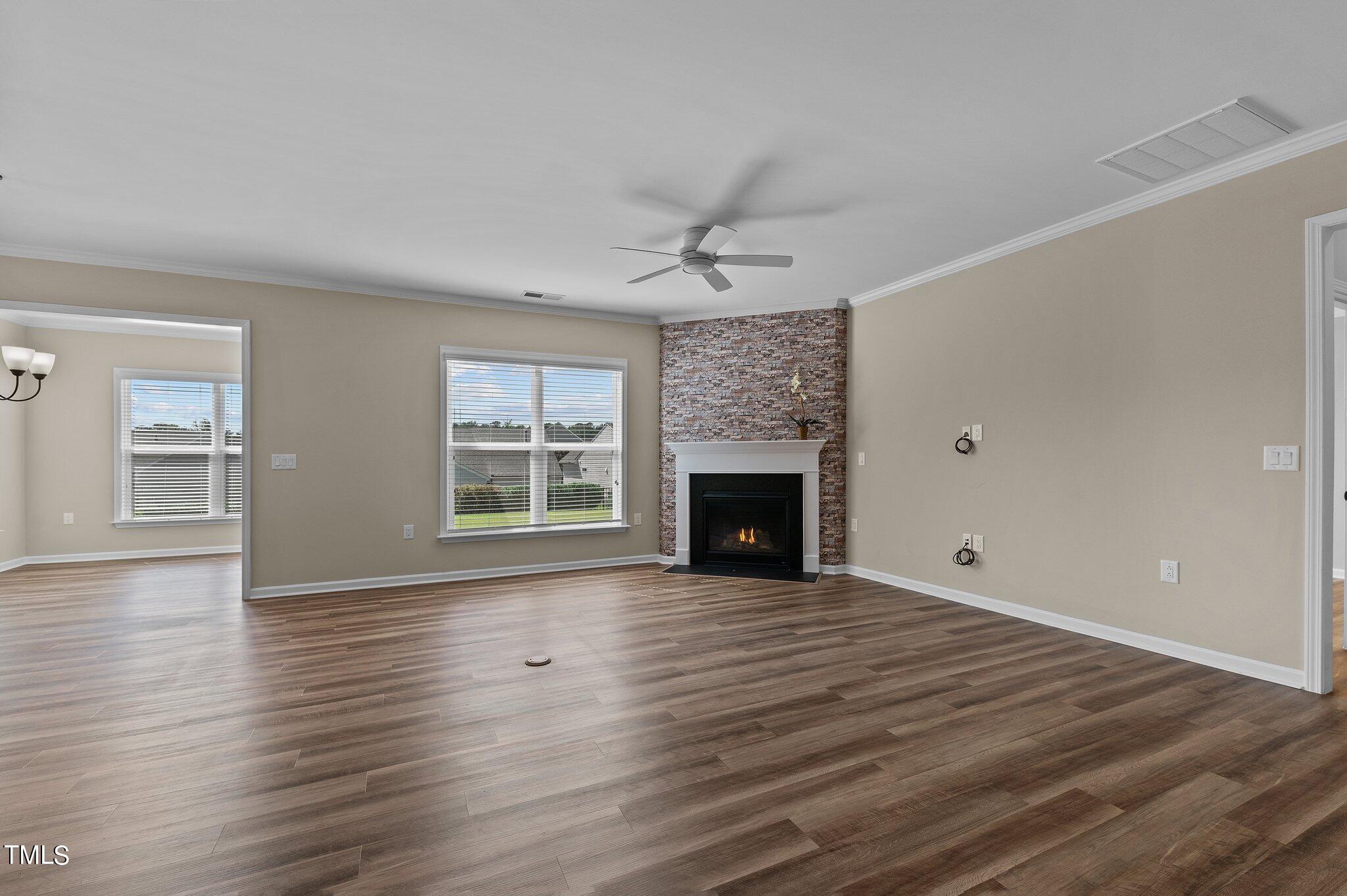 1013 Calista Drive Wake Forest, NC 27587 - Photo 13 of 40 a view of an empty room with wooden floor fireplace and a window