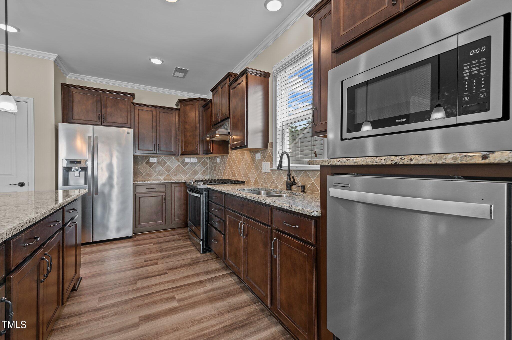 1013 Calista Drive Wake Forest, NC 27587 - Photo 18 of 40 a kitchen with stainless steel appliances a stove sink microwave and cabinets