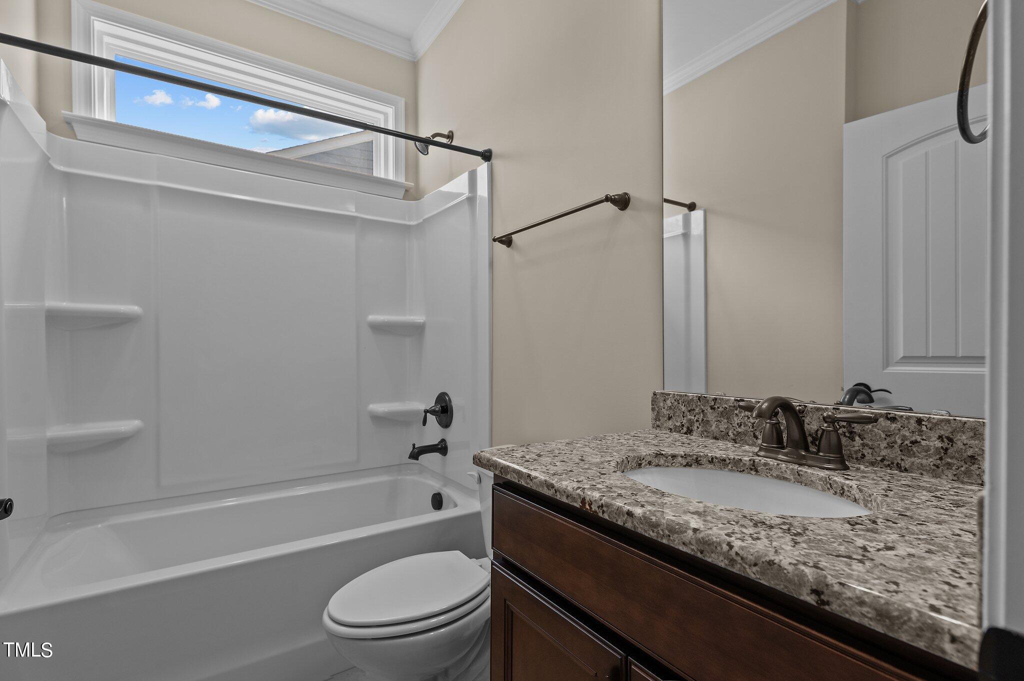 1013 Calista Drive Wake Forest, NC 27587 - Photo 9 of 40 a bathroom with a granite countertop sink a toilet and bathtub