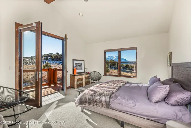 a bedroom with a bed and large windows