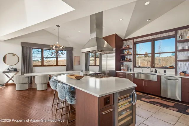a open kitchen with stainless steel appliances granite countertop a stove and a table chair