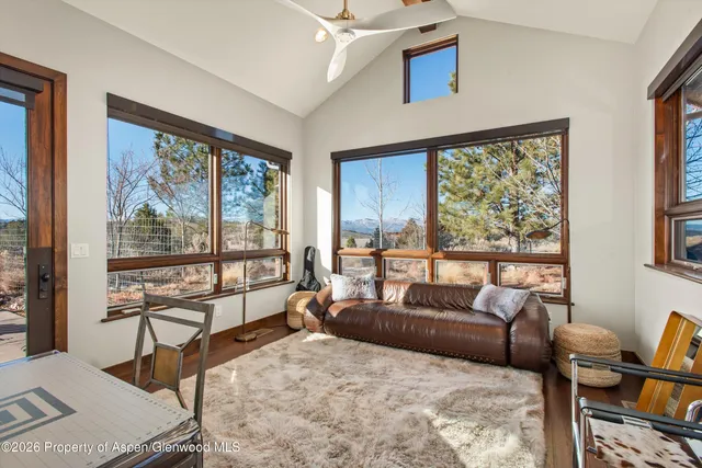 a living room with furniture and a floor to ceiling window