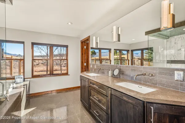 a spacious bathroom with double vanity and a mirror