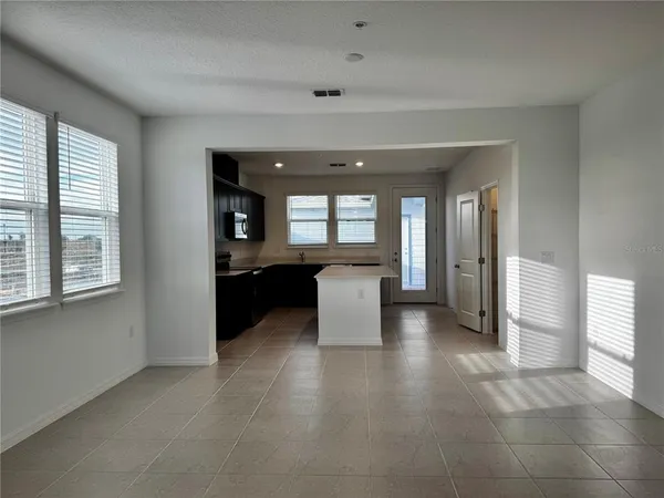 a kitchen with stainless steel appliances granite countertop a refrigerator a sink a stove a microwave and island