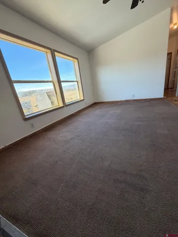 an empty room with a window and a fan