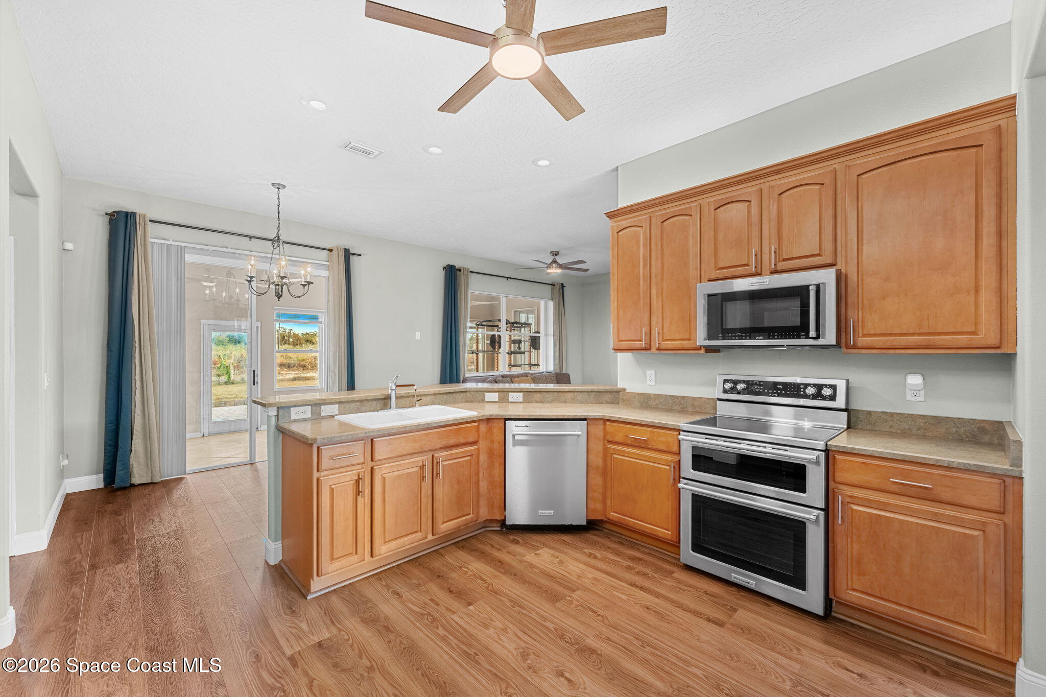 1305 Pemberton Trail Malabar, FL 32950 - Photo 13 of 69 a kitchen with stainless steel appliances granite countertop wooden cabinets and a stove top oven