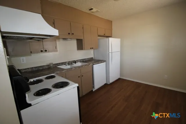 a kitchen with a stove and a refrigerator