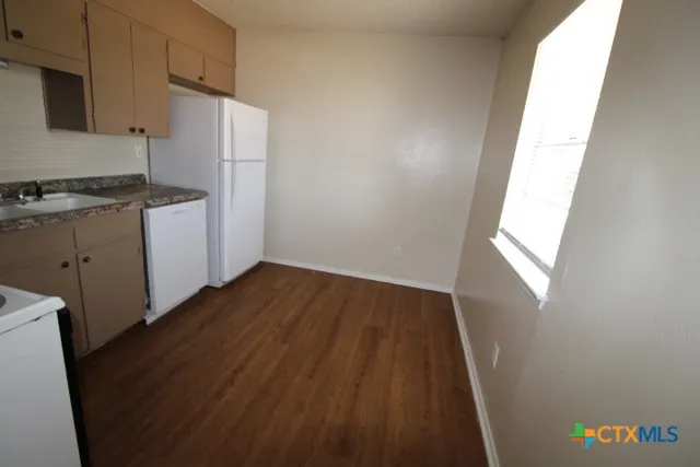 a kitchen with a refrigerator and a stove
