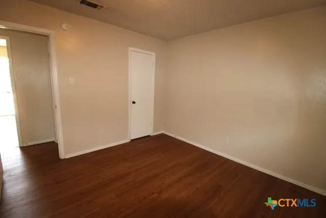 a view of an empty room with wooden floor