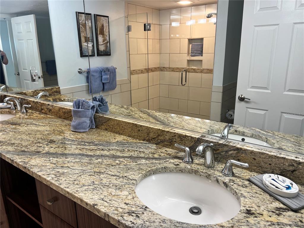 1001 Point Of Rocks Road, Unit 212 Sarasota, FL 34242 - Photo 12 of 36 a bathroom with a granite countertop sink and a mirror
