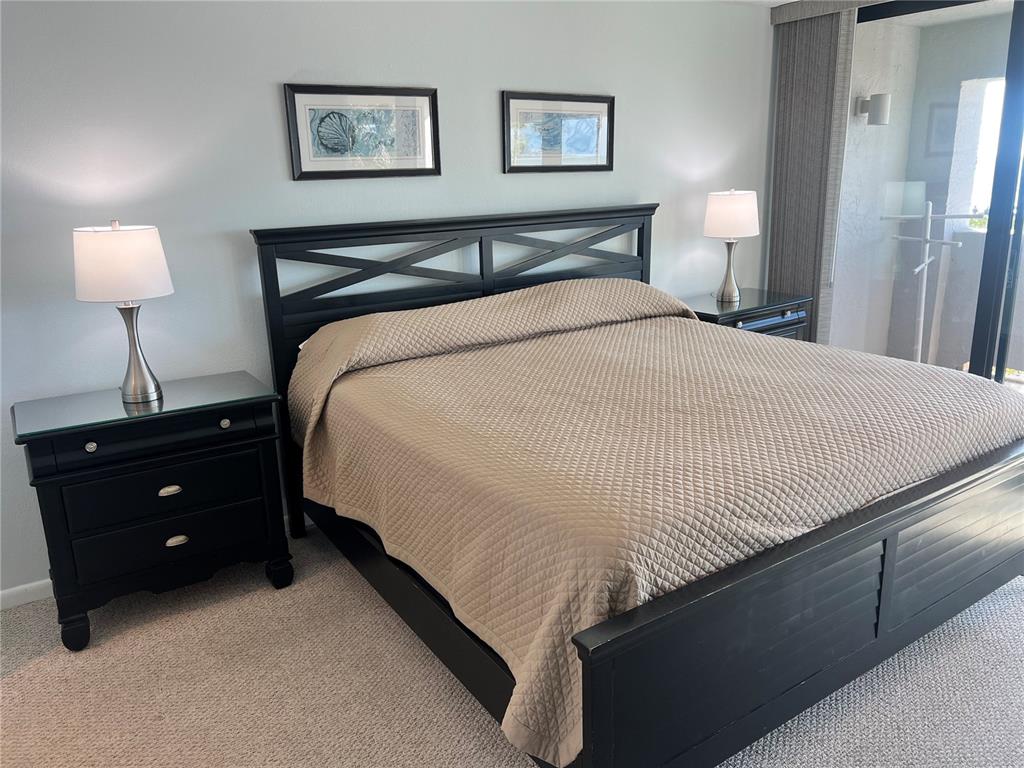 1001 Point Of Rocks Road, Unit 212 Sarasota, FL 34242 - Photo 14 of 36 a bedroom with a bed and a lamp