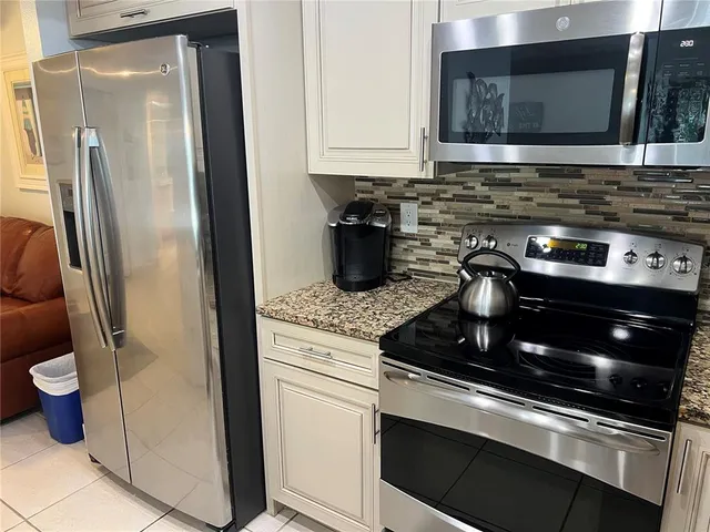 a kitchen with stainless steel appliances granite countertop a stove a microwave and a sink