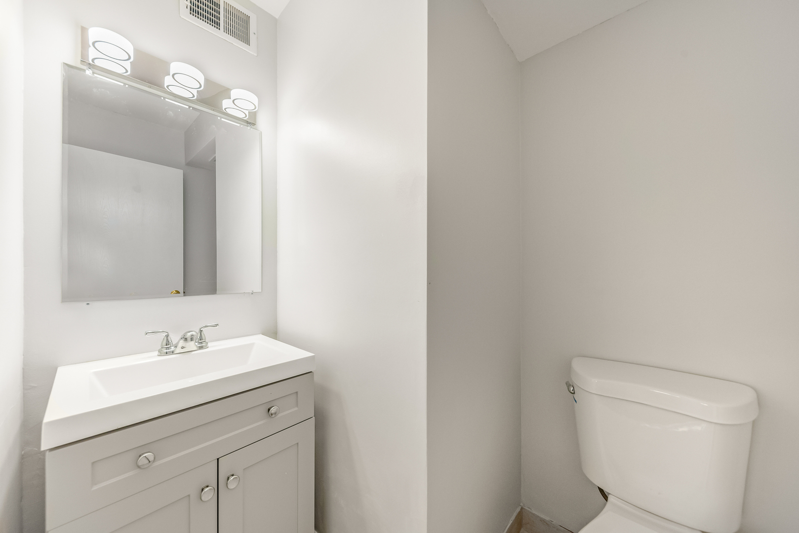 404 East Kensington Road, Unit C Mount Prospect, IL 60056 - Photo 11 of 16 a bathroom with a toilet sink and mirror