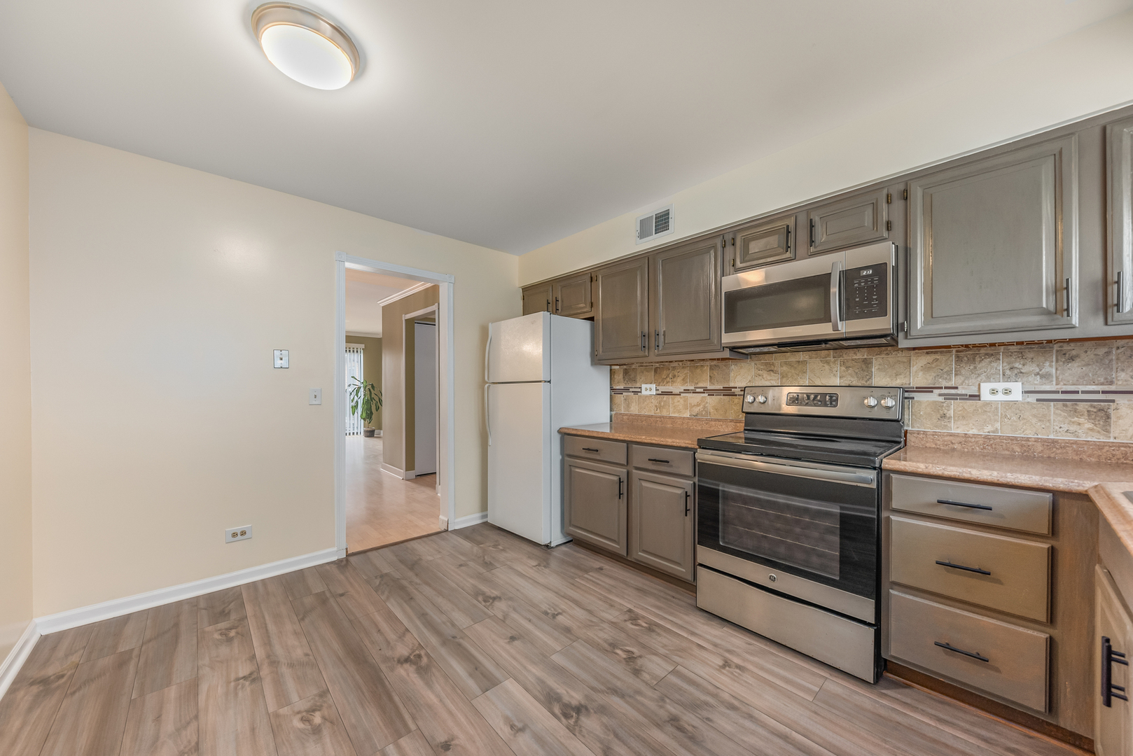 404 East Kensington Road, Unit C Mount Prospect, IL 60056 - Photo 4 of 16 a kitchen with stainless steel appliances granite countertop a stove and a refrigerator