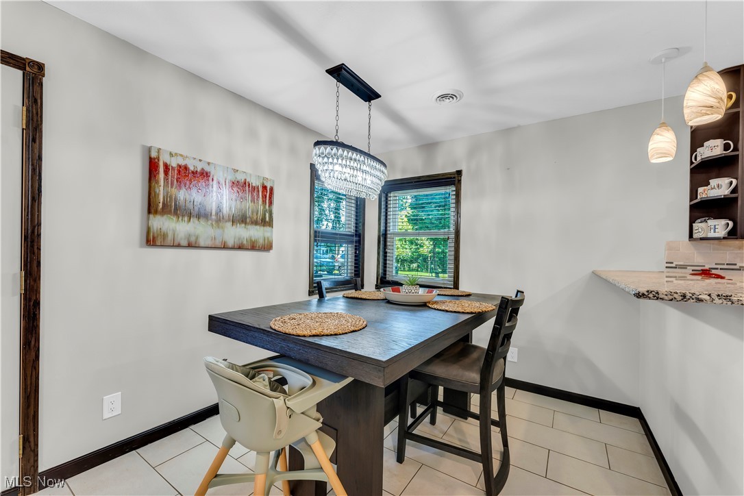 7479 Macedonia Road Bedford, OH 44146 - Photo 22 of 42 Tiled dining space featuring a notable chandelier