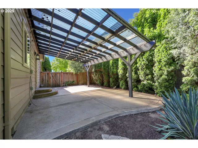 a backyard of a house with wooden floor table and chairs