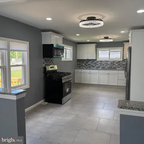 a kitchen with stainless steel appliances granite countertop a stove and a refrigerator
