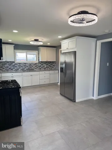 a kitchen with stainless steel appliances granite countertop a refrigerator and a stove