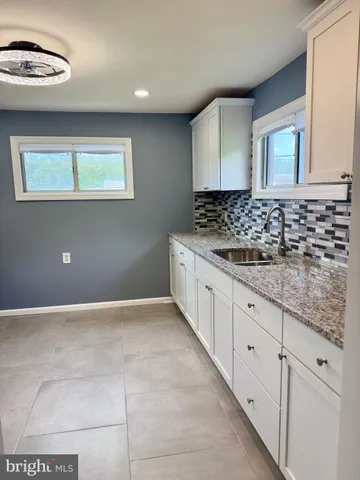 a kitchen with granite countertop a sink and cabinets
