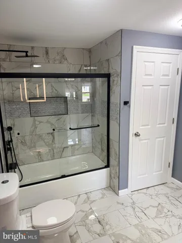 a bathroom with a toilet and a shower
