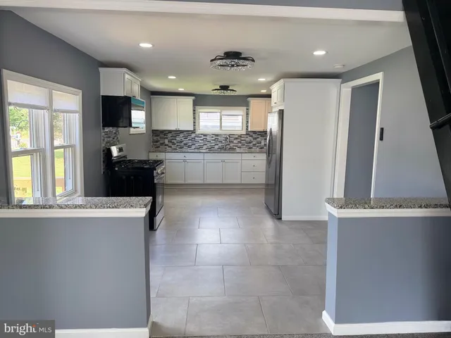 a large bathroom with a large mirror vanity and stainless steel appliances
