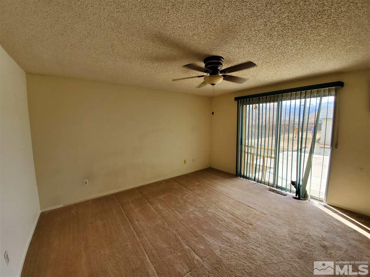 216 Ring Road Dayton, NV 89403 - Photo 8 of 14 an empty room with a ceiling fan and a window