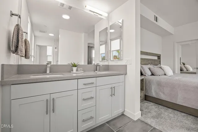 a en suite bathroom with double sink and a large mirror