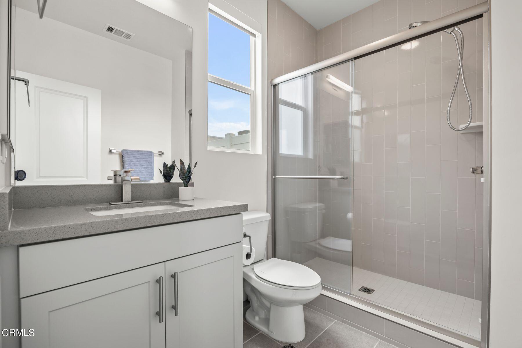 1290 East Thompson Boulevard, Unit 102 Ventura, CA 93001 - Photo 19 of 26 a bathroom with a shower sink vanity mirror and toilet