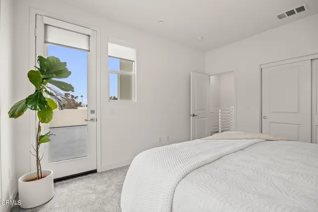 a bedroom with a bed and a potted plant