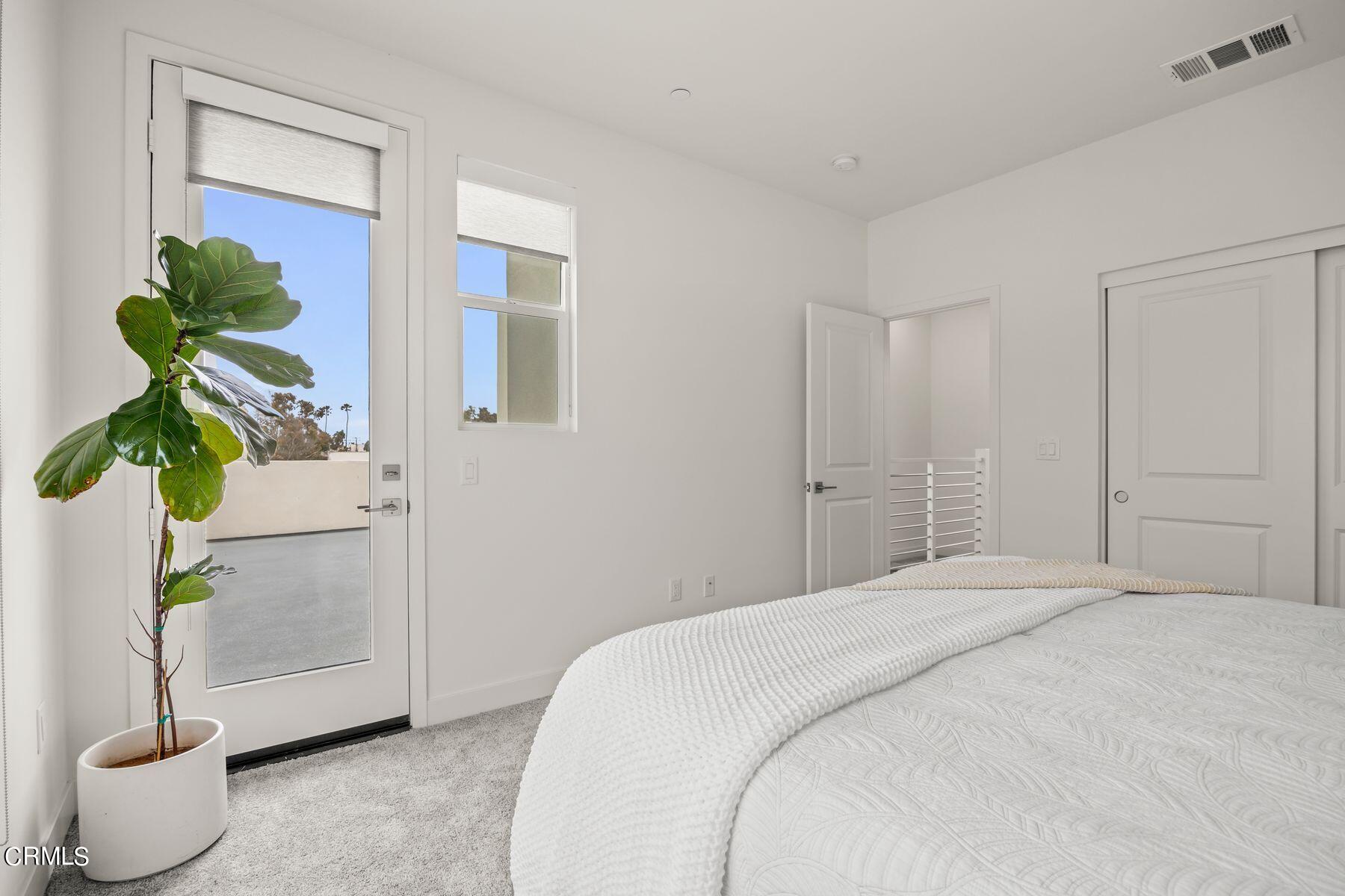 1290 East Thompson Boulevard, Unit 102 Ventura, CA 93001 - Photo 20 of 26 a bedroom with a bed and a potted plant