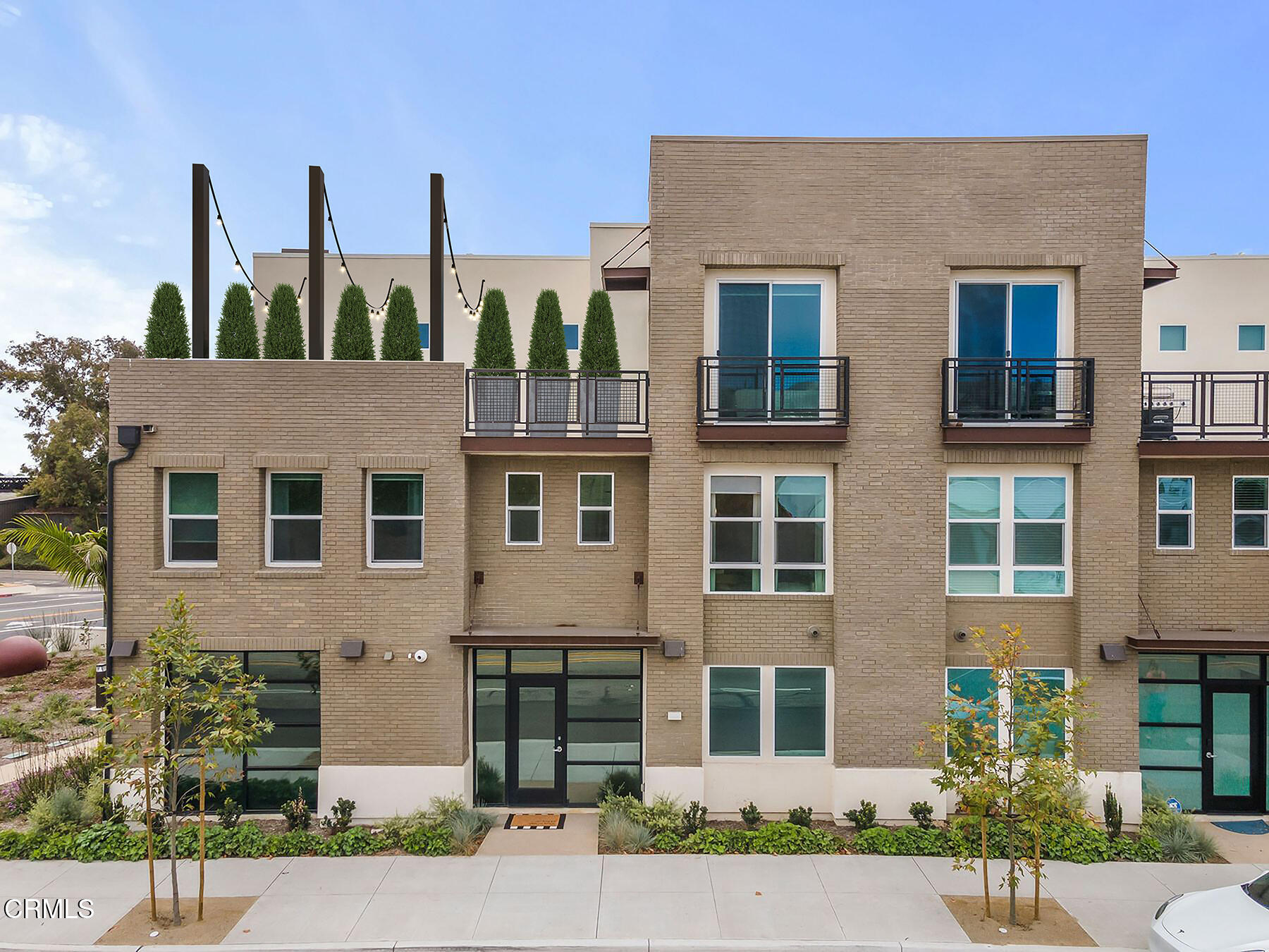 1290 East Thompson Boulevard, Unit 102 Ventura, CA 93001 - Photo 2 of 26 a view of a brick building next to a yard