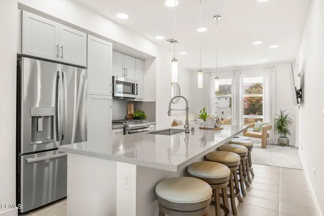 a kitchen with sink refrigerator and microwave