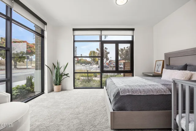 a bed sitting in a bedroom next to a large window