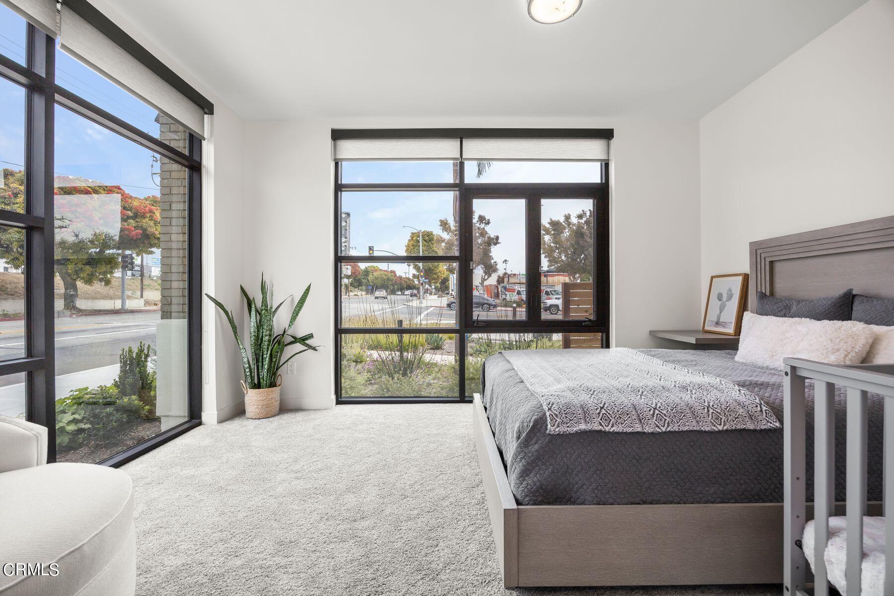 1290 East Thompson Boulevard, Unit 102 Ventura, CA 93001 - Photo 6 of 26 a bed sitting in a bedroom next to a large window