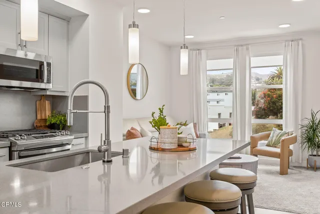 a kitchen with a table chairs stove and kitchen view