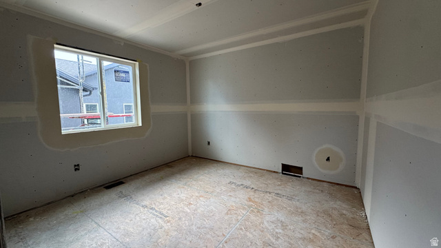 1862 Mantle Way, Unit 418 Tooele, UT 84074 - Photo 7 of 10 Room featuring a large window, drywall-finished walls, crown molding, and subflooring