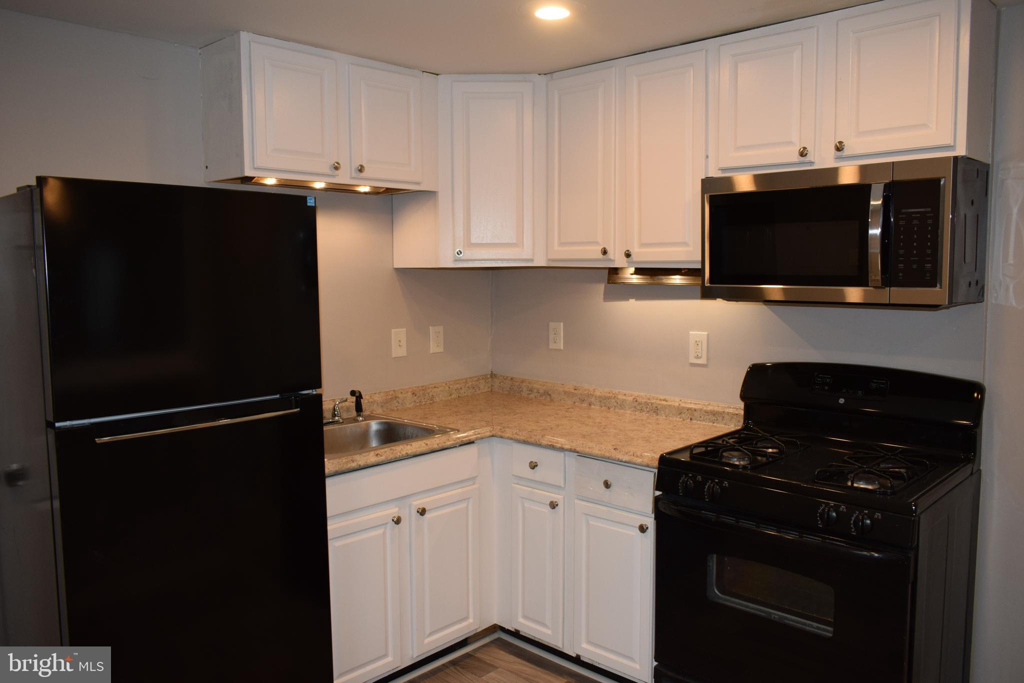 346 South Payson Street Baltimore, MD 21223 - Photo 5 of 29 a kitchen with a refrigerator and a stove top oven