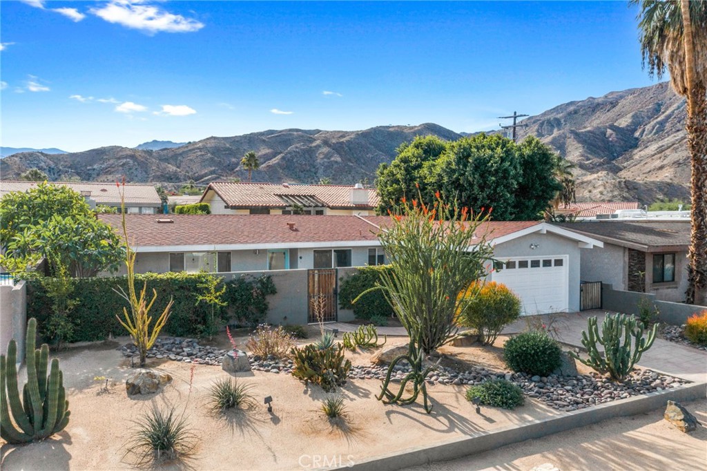 a front view of house with yard and mountain in the background
