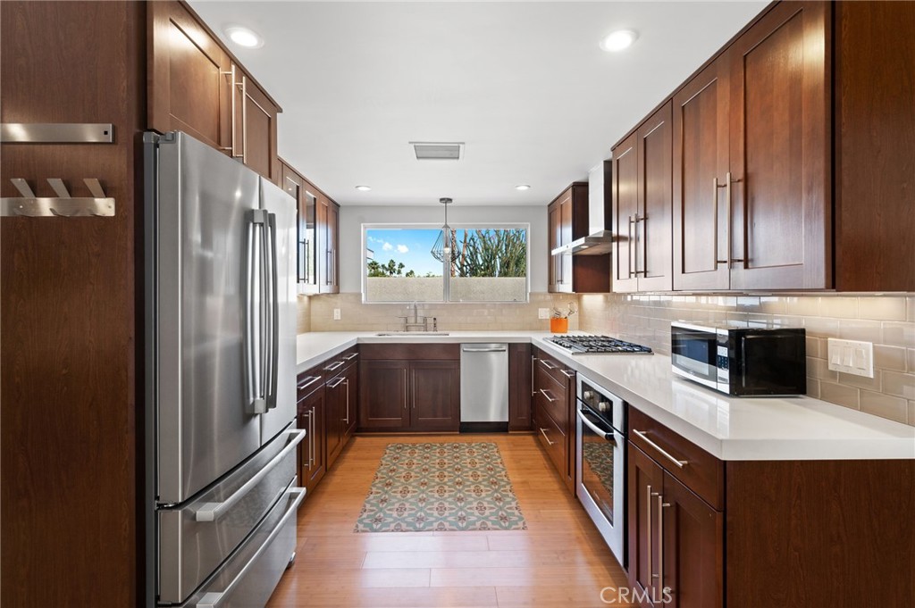 72543 Beavertail Street Palm Desert, CA 92260 - Photo 14 of 45 a kitchen with stainless steel appliances granite countertop a refrigerator a stove a sink and a microwave