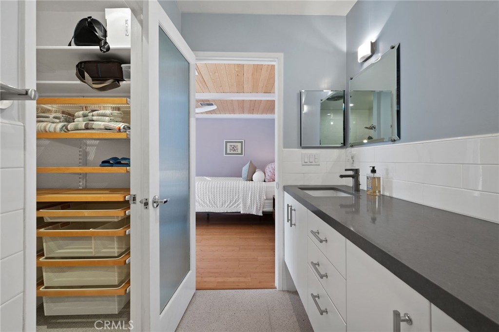 72543 Beavertail Street Palm Desert, CA 92260 - Photo 33 of 45 a en suite bathroom with a granite countertop sink and a mirror