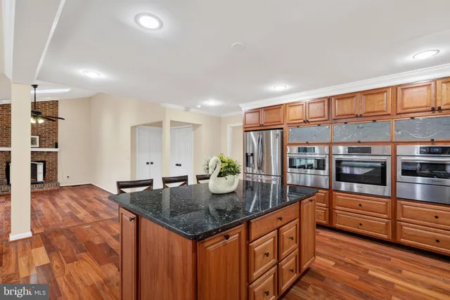 a kitchen with stainless steel appliances granite countertop a refrigerator and a stove top oven