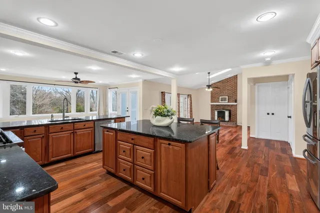 a kitchen with stainless steel appliances granite countertop sink stove top oven and cabinets