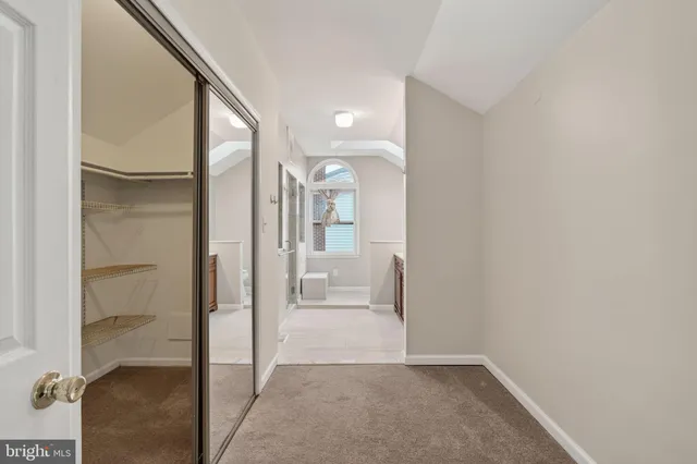 an empty room with windows and ceiling fan