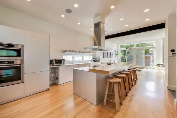 a kitchen with stainless steel appliances granite countertop a sink a stove and a refrigerator