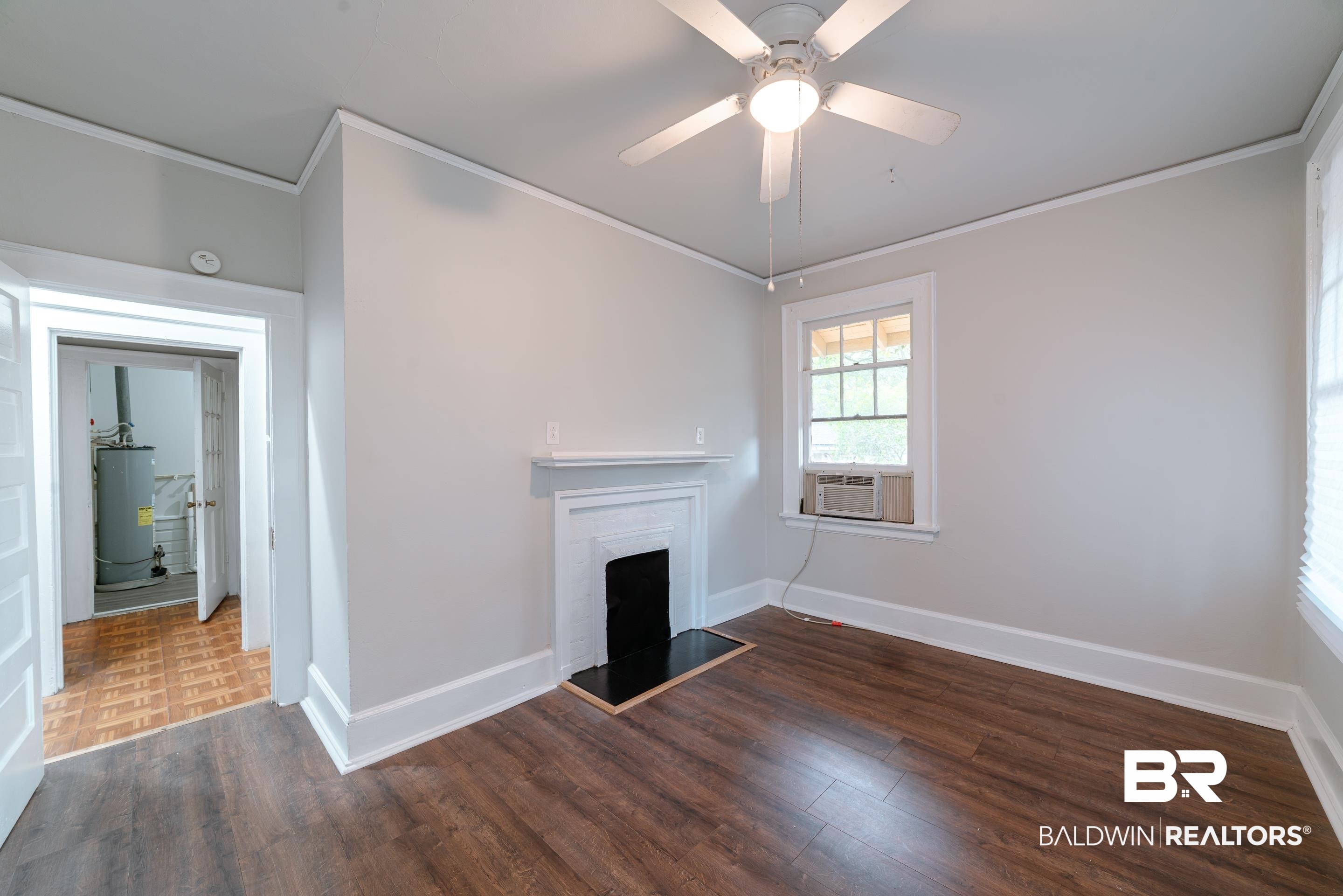 312 1st Street Mobile, AL 36611 - Photo 18 of 29 Unfurnished living room featuring dark wood-type flooring, water heater, cooling unit, crown molding, and ceiling fan