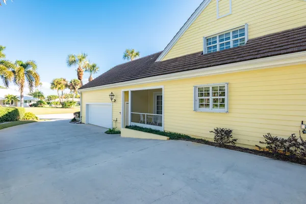 a front view of a house with swimming pool and porch with furniture
